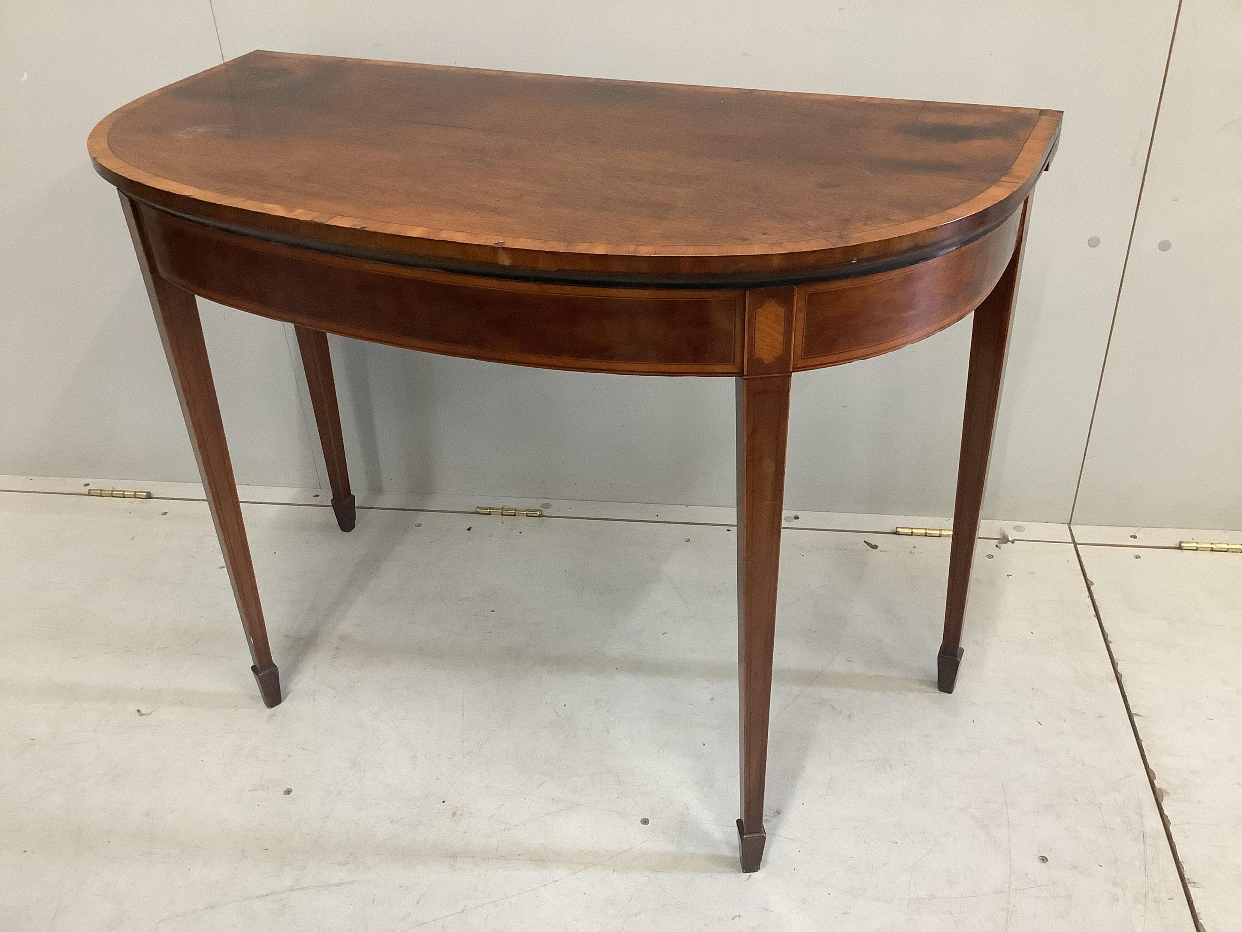 A George III banded mahogany D shaped folding card table, width 99cm, depth 48cm, height 73cm. Condition - poor to fair